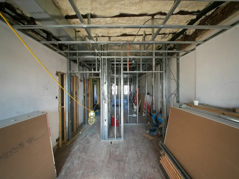 Interior job site with metal stud framing and drywall panels
