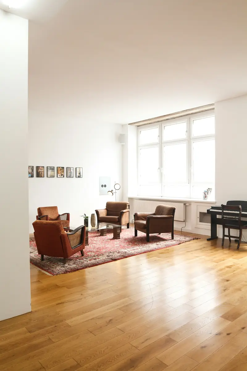 Room with a warm wooden parquet floor and white walls