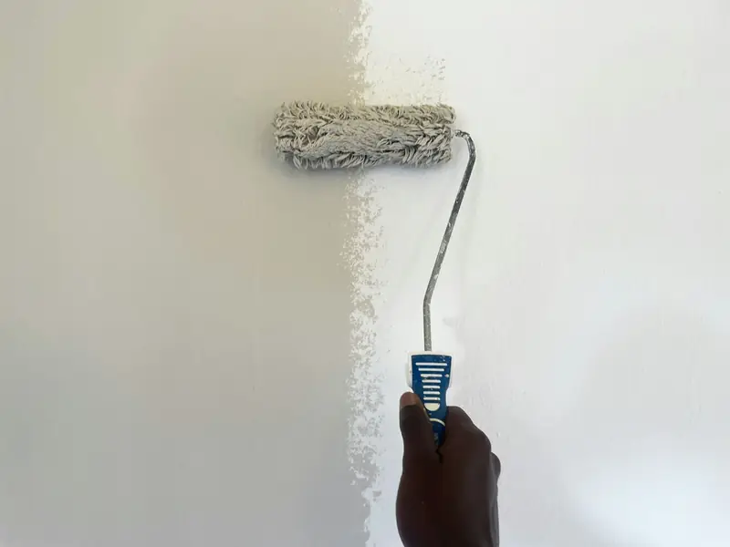 Paint roller applying a fresh coat to a wall